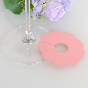 Close-up of pink flower-shaped wine glass name card for festive table settings