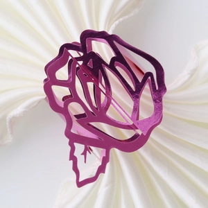 Macro view of purple hollow rose napkin ring with a polished metallic laser-cut finish