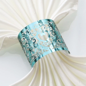 Detail view of teal metal napkin ring with laser-cut heart and vintage scroll patterns