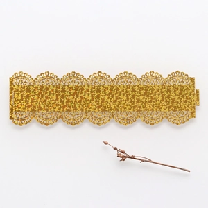 Macro shot of glittery golden lace pattern trim for wedding napkins and party decor