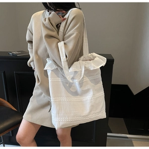 Détail du grand sac cabas blanc en toile avec texture gaufrée et bord volanté