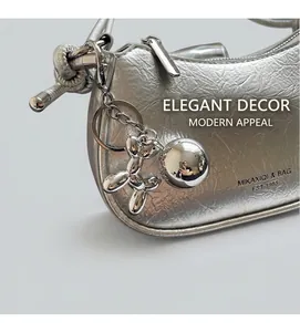 Detail of silver metallic wrinkled PU bag with cute balloon dog and mirror ball charms