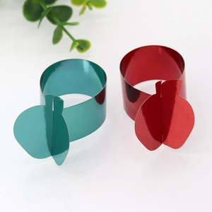 Detail of red and green apple napkin rings with glossy metallic finish and 3D design