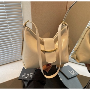 Detailed texture of off-white oil wax leather hobo bag with gold curved metal trim