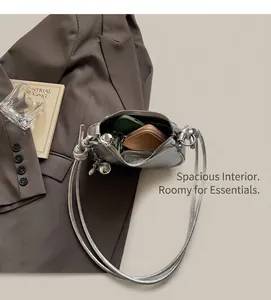 Interior view showing the large capacity of a silver metallic crossbody bag with accessories