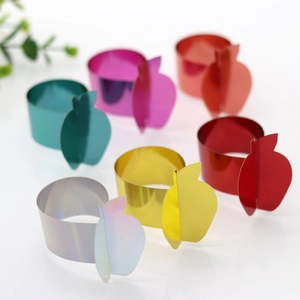 Close-up of apple-shaped napkin rings with a metallic mirror finish in multiple colors