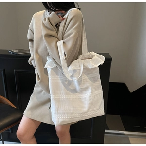 Sac cabas en toile blanche avec bords en dentelle plissée et texture rayée à l'épaule