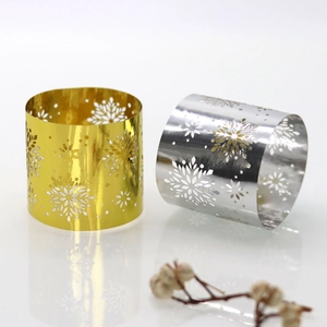 Macro detail of laser-cut snowflake patterns on metal napkin rings for Christmas dining