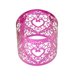 Detail view of pink laser-cut napkin ring with intricate heart and scroll patterns