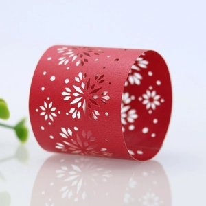 Macro shot of laser-cut red snowflake paper napkin rings for elegant Christmas table decor