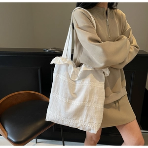 Gros plan du sac cabas en dentelle blanche avec broderies et détails à volants doux