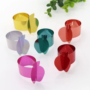 Close-up of apple-shaped napkin rings in various metallic colors for festive table decor