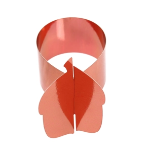 Close-up of metallic red leaf-shaped napkin ring with overlapping lock closure