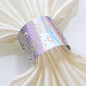 Macro shot of a holographic snowflake napkin ring with laser-cut details on white satin