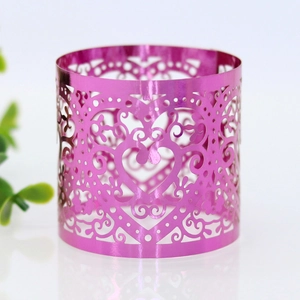 Macro detail of laser-cut pink metallic heart napkin ring with elegant hollow floral patterns