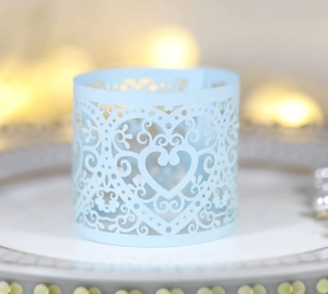 Macro detail of laser-cut light blue cupcake wrapper with heart and swirl pattern