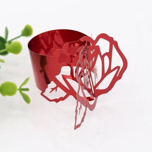Detail of red rose paper napkin ring with laser-cut floral design for wedding decor