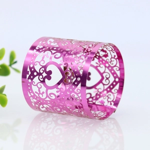 Macro detail of laser-cut pink heart napkin ring with floral hollow patterns for weddings