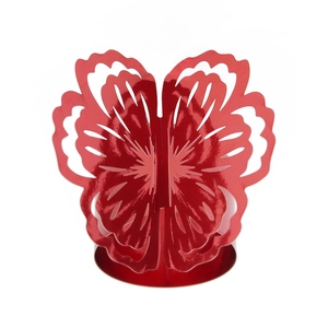 Macro detail of laser-cut red butterfly napkin ring with intricate hollow floral patterns