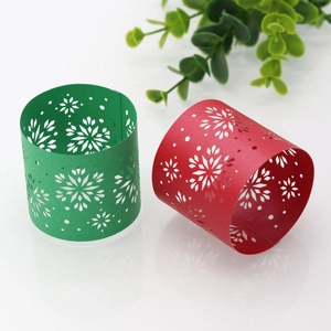 Laser-cut paper napkin rings with snowflake patterns in festive red and green colors
