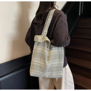 Détail d'un grand sac cabas en toile vichy verte avec motifs géométriques tissés