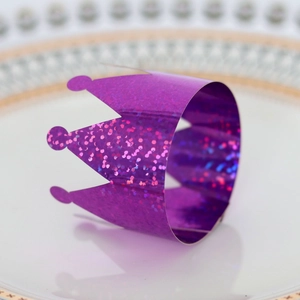 Detail of purple glitter crown napkin ring on a white porcelain plate for table setting