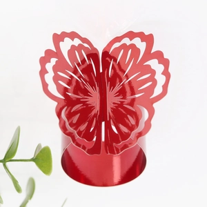 Close-up of a red metallic butterfly napkin ring with intricate hollowed-out carvings