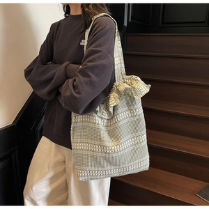 Détail du sac cabas en toile vichy vert avec des bretelles à volants élégantes