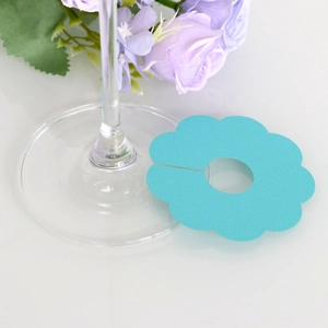 Detailed teal floral paper place card with central cutout for wine glass stems