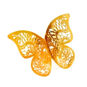 Detailed view of golden butterfly napkin ring with intricate laser-cut lace patterns