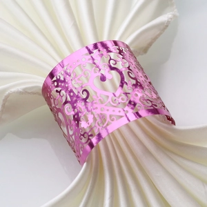 Close-up of pink heart laser-cut napkin ring on elegant folded white satin fabric