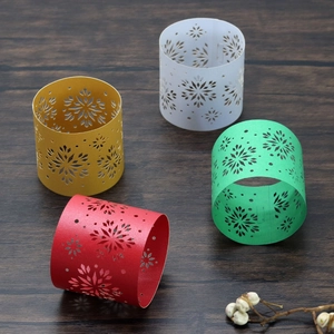 Macro shot of laser-cut paper napkin rings with snowflake patterns on dark wood
