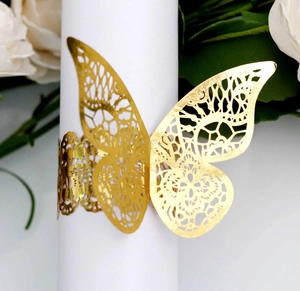 Macro detail of golden laser-cut butterfly napkin ring with intricate lace texture