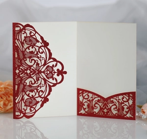 Detail of red laser cut glitter invitation card with intricate hollow floral patterns