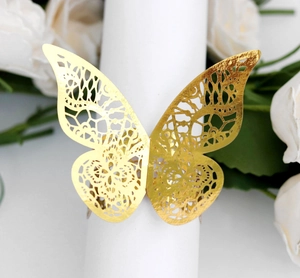Macro detail of gold laser-cut butterfly napkin ring with intricate lace texture