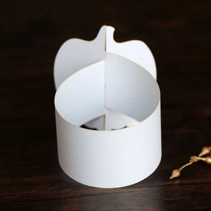 Macro view of white pumpkin-shaped paper base with interlocking slot design
