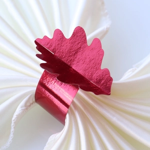 Gros plan d'un rond de serviette en forme de feuille d'érable rouge sur satin blanc