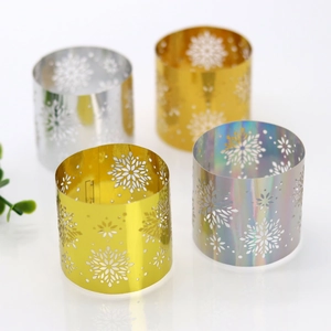 Detailed macro view of festive snowflake hollow metal napkin rings in gold and silver finish