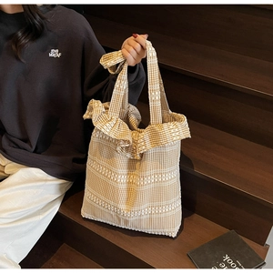 Détail du sac cabas en toile avec motif vichy marron et bords à volants sur les côtés