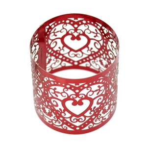 Detail of red laser-cut cupcake wrappers with hollow heart and vine patterns for weddings
