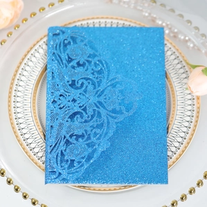 Detail of glitter laser-cut floral invitation cover in bright blue for luxury weddings