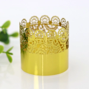 Detailed close-up of golden laser-cut lace pattern on festive paper cupcake wrappers