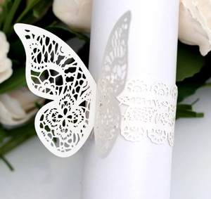 Detail of laser-cut butterfly napkin ring with intricate white lace patterns