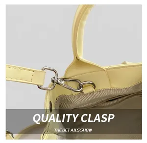 Detail showing high-quality silver metal hook and interior zipper pocket of yellow bucket bag