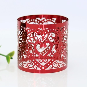 Detailed view of red metallic heart napkin ring with laser-cut filigree patterns