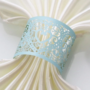 Macro shot of light blue laser-cut heart napkin ring with ornate vine patterns
