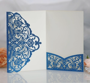 Macro view of navy blue glitter laser cut wedding invitation with intricate floral lace