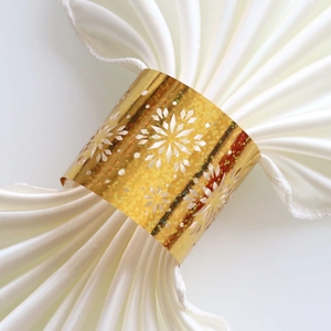 Detail of elegant gold snowflake napkin ring with hollow design and glitter finish