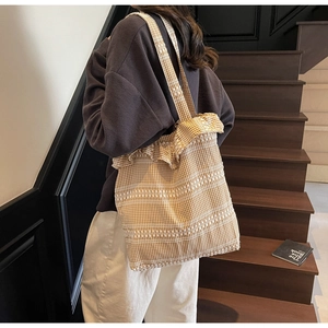 Détail du sac cabas en toile à carreaux jaunes avec bordure à volants et rayures tissées