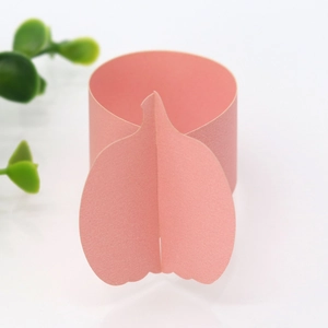 Close-up of pink laser-cut pumpkin napkin ring made of shimmer paper for table decor